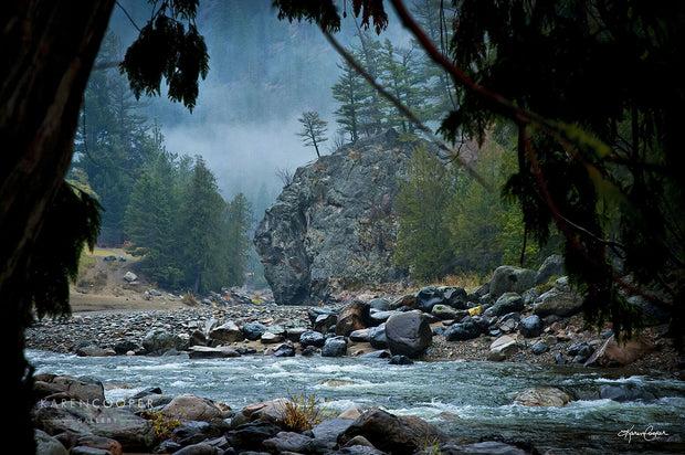 Fine art luxury nature landscape contemporary photography by Karen Cooper Gallery A large boulder jutting into the similkameen river, covered in smaller, blue, grey, and black stones on a misty day  with a rapid river in British Columbia Canada 