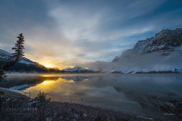 Fine art luxury nature landscape contemporary photography by Karen Cooper Gallery A large, still lake perfectly reflecting the blue, twilight sky and the remaining golden sun rays seen just over the snow-capped mountains. in the winter in a Alberta provincial park in Canada  