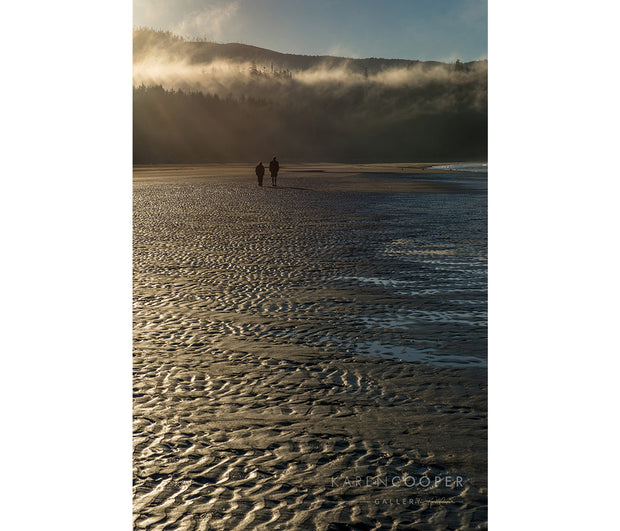 Fine art luxury nature landscape contemporary photography by Karen Cooper Gallery A misty beach near sunset with two human figures walking away from the camera on misty morning at dawn on Vancouver Island British Columbia Canada 