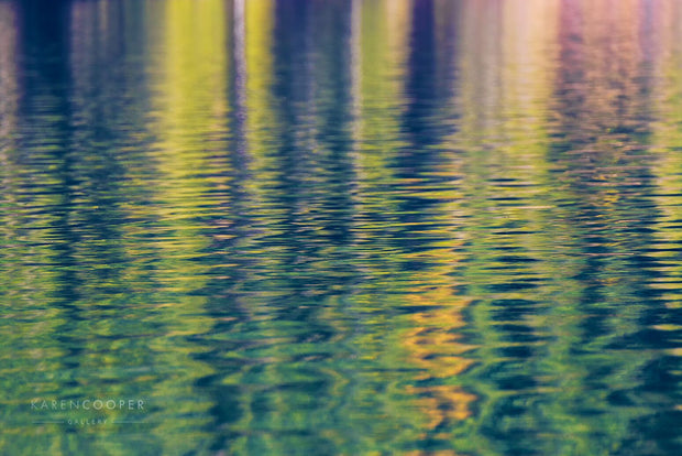 green trees reflected in rippling water